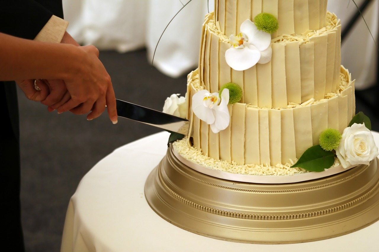 Cutting The First Tier Of A White Mastic Wedding Cake In A Banquet Hall  Background Wedding Cake Cutting Sweet Moment Wedding Traditions Cake  Etiquette Ways Of Cutting A Wedding Cake Stock Photo -