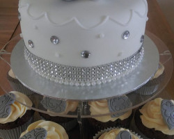 25 Year Anniversary Cake iced White with Silver Decorations and Cream and Grey Decorated Cupcakes
