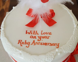 Ruby Anniversary Cake Iced White with Decorative Edging Red Ribbons topped with White Feathers and Red Love Hearts 4